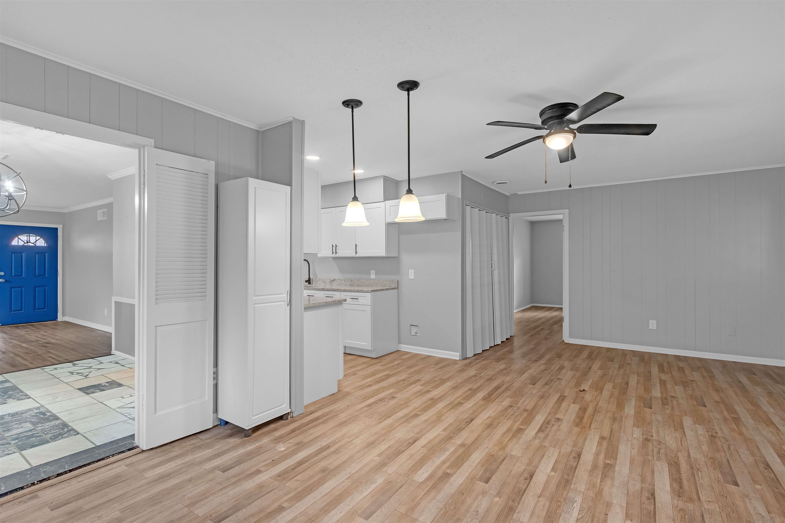 1303 Inman Road Memphis, TN 38111 - Photo 6 of 12 Unfurnished living room with ceiling fan with notable chandelier, baseboards, crown molding, and light wood-style floors