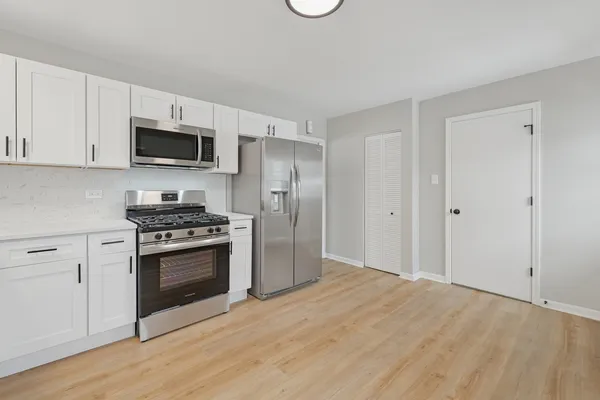 a kitchen with stainless steel appliances granite countertop a stove a refrigerator and a microwave