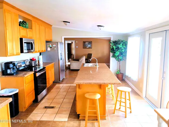a kitchen with granite countertop a sink a counter top space and cabinets