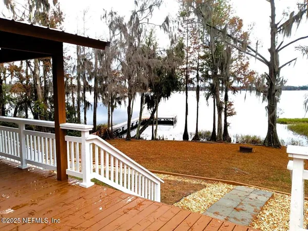 a view of a house with backyard and trees