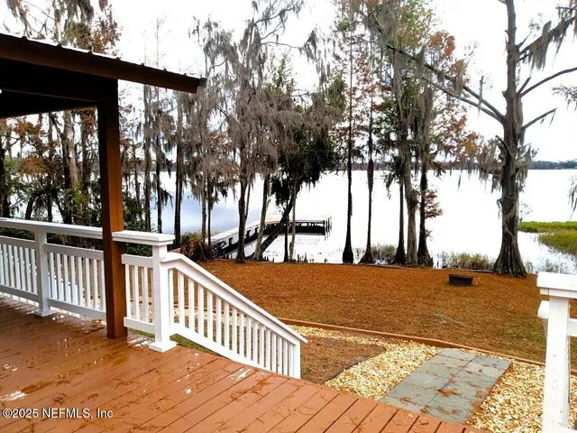 a view of a house with backyard and trees