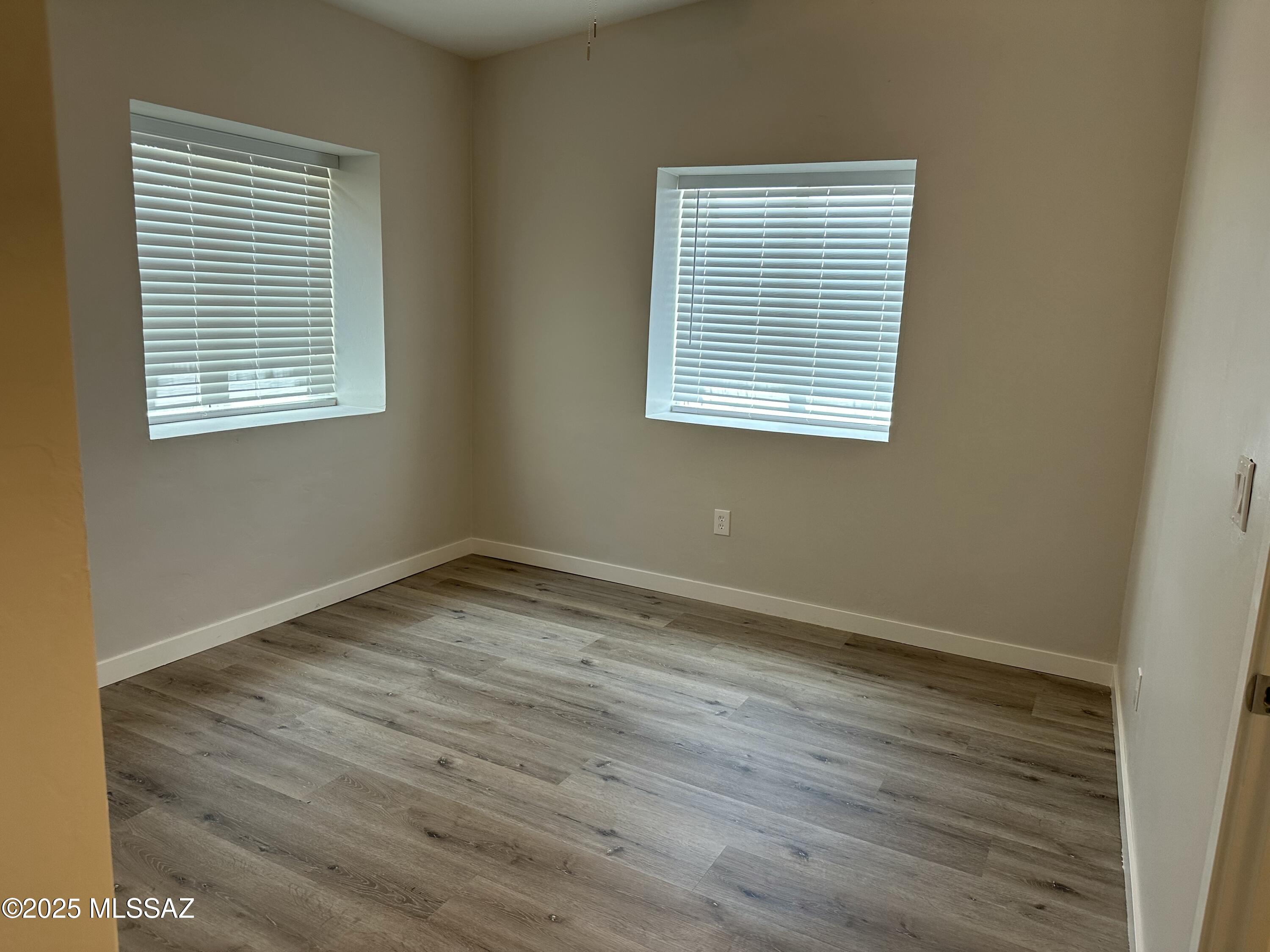 645 East Mabel Street Tucson, AZ 85705 - Photo 13 of 22 a view of an empty room with wooden floor and a window