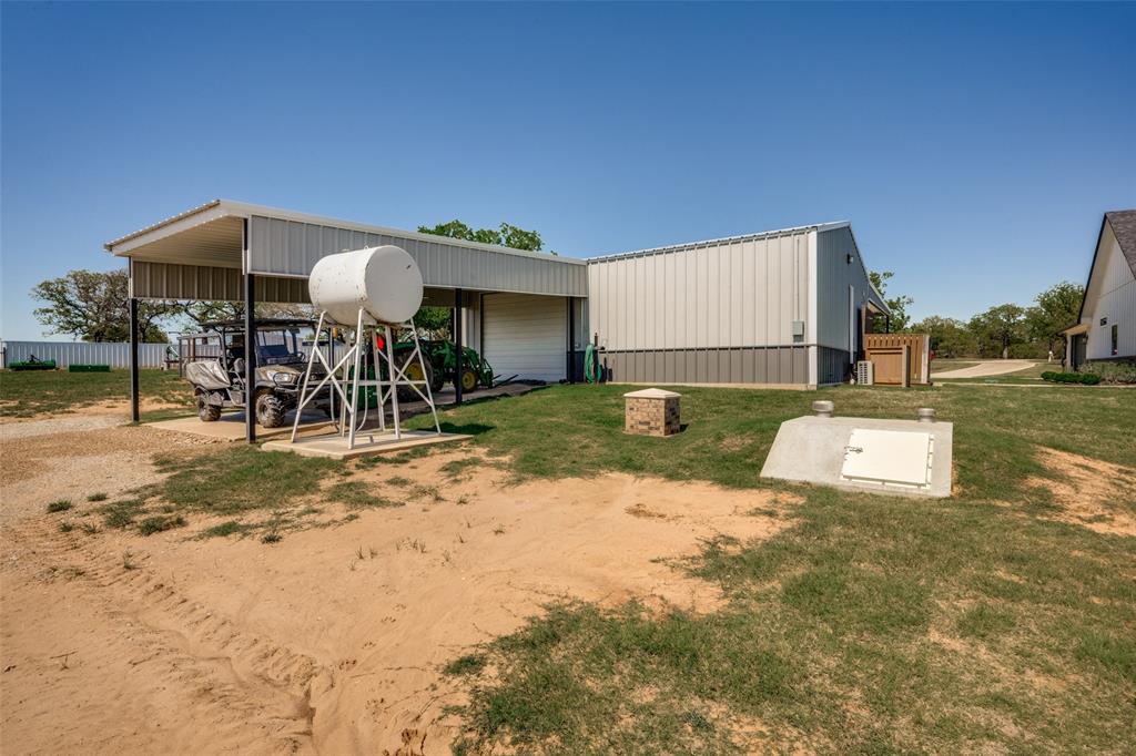 250 Belcher Road Bowie, TX 76230 - Photo 34 of 38 view of back of shop, additional covered parking, storm cellar