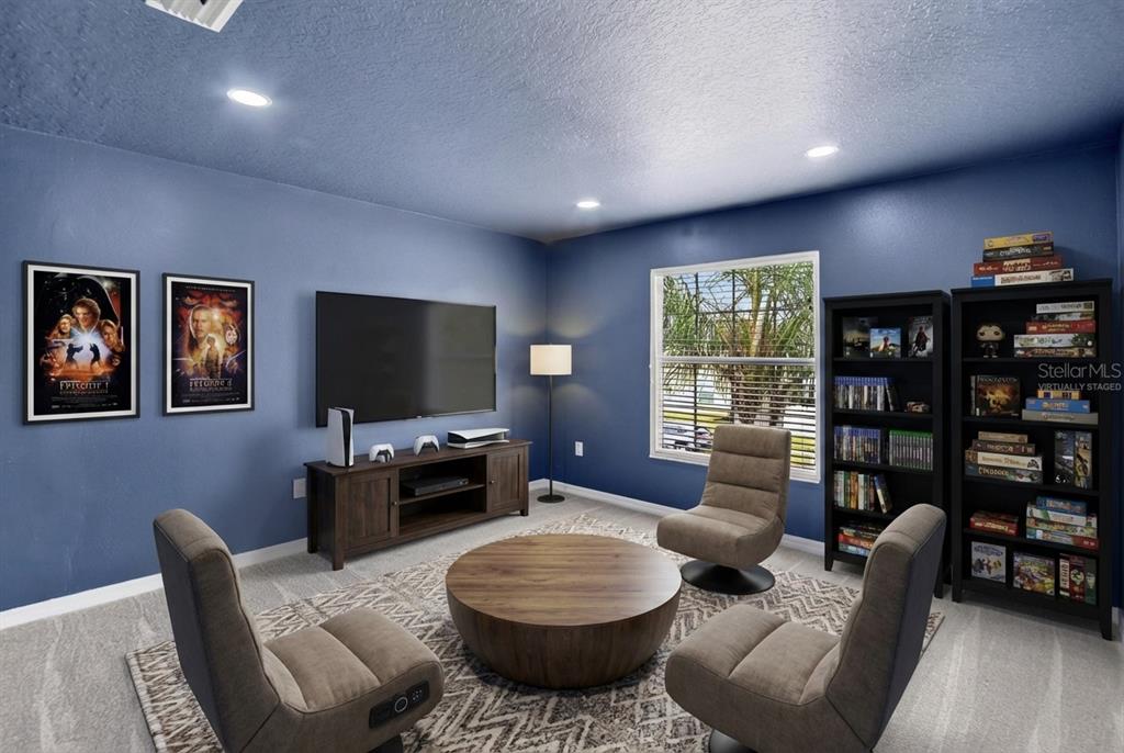 11543 Addison Chase Drive Riverview, FL 33579 - Photo 30 of 45 a living room with furniture a flat screen tv and a bookshelf