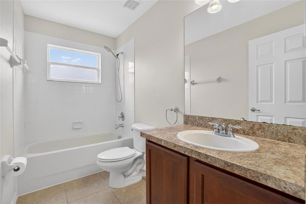 11543 Addison Chase Drive Riverview, FL 33579 - Photo 34 of 45 a bathroom with a granite countertop sink a toilet and shower