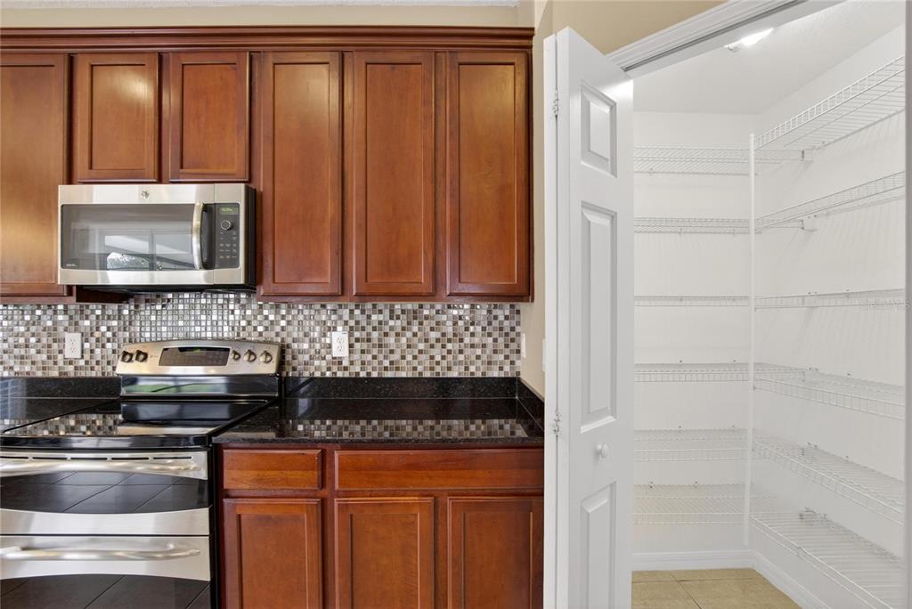 11543 Addison Chase Drive Riverview, FL 33579 - Photo 7 of 45 a kitchen with granite countertop stainless steel appliances a stove microwave and refrigerator