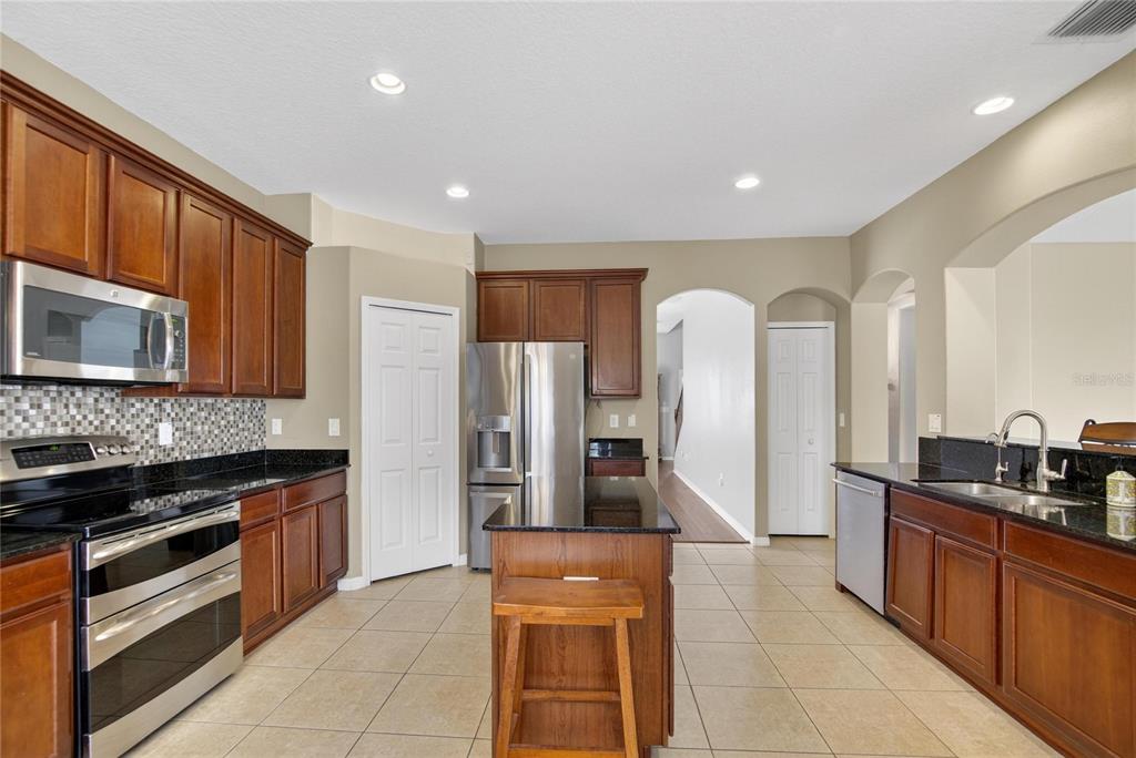11543 Addison Chase Drive Riverview, FL 33579 - Photo 9 of 45 a kitchen with stainless steel appliances granite countertop a refrigerator and a stove top oven