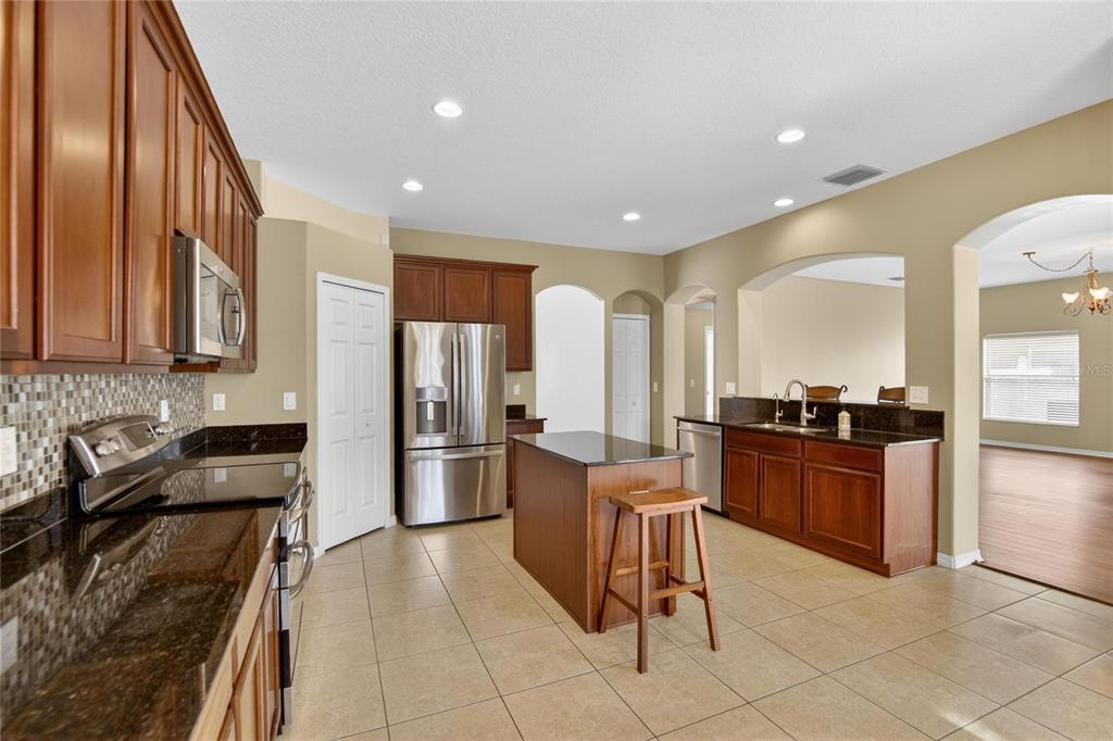 11543 Addison Chase Drive Riverview, FL 33579 - Photo 10 of 45 a kitchen with stainless steel appliances granite countertop a refrigerator and a stove top oven