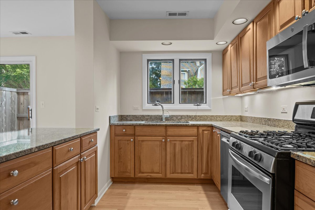 62 East Center Avenue, Unit 62 Lake Bluff, IL 60044 - Photo 11 of 19 a kitchen with granite countertop a sink stove and cabinets