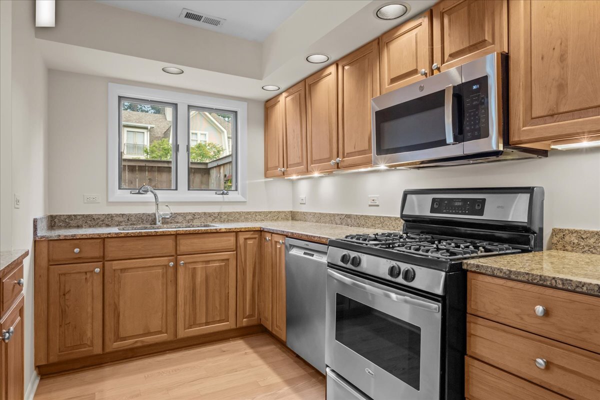 62 East Center Avenue, Unit 62 Lake Bluff, IL 60044 - Photo 12 of 19 a kitchen with granite countertop a stove a sink and wooden cabinets