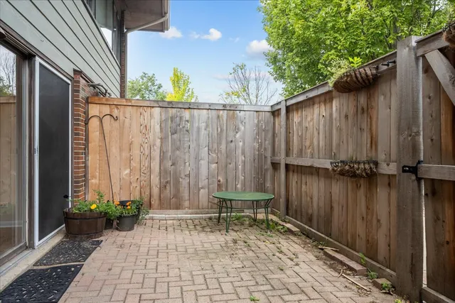 a view of a backyard with a chair and potted plants
