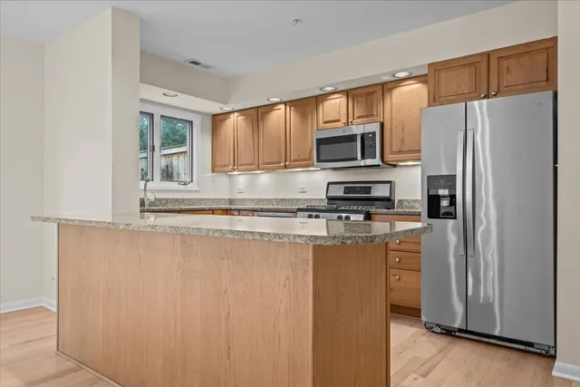 a kitchen with stainless steel appliances a refrigerator stove and microwave