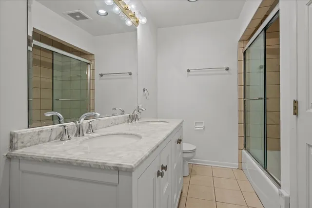 a bathroom with a granite countertop sink a toilet and shower