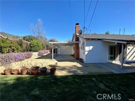a view of an house with backyard space and balcony
