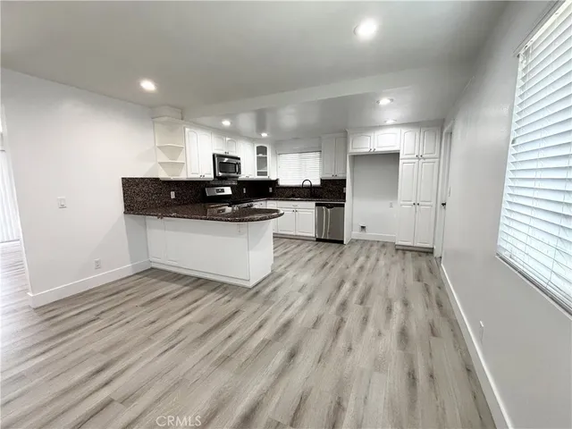a kitchen with a sink and wooden floor