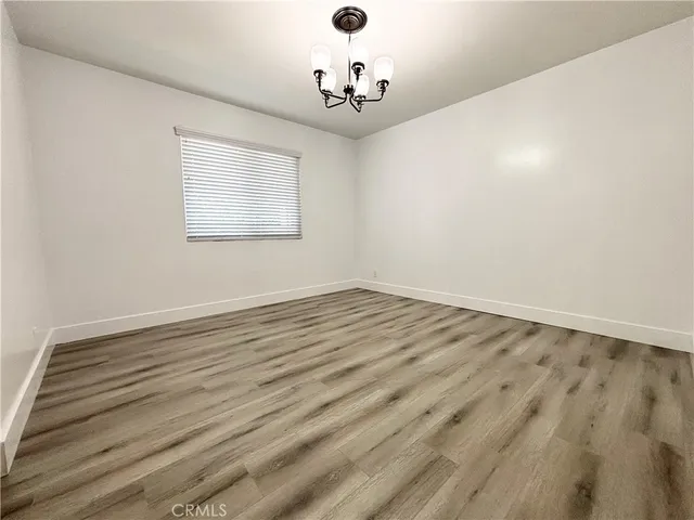 a view of a room with wooden floor and ceiling fan
