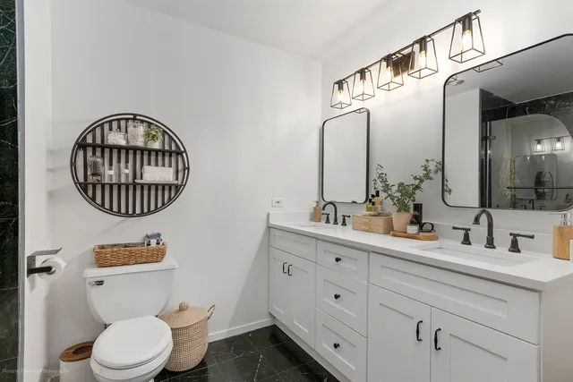 a bathroom with a toilet a sink and mirror