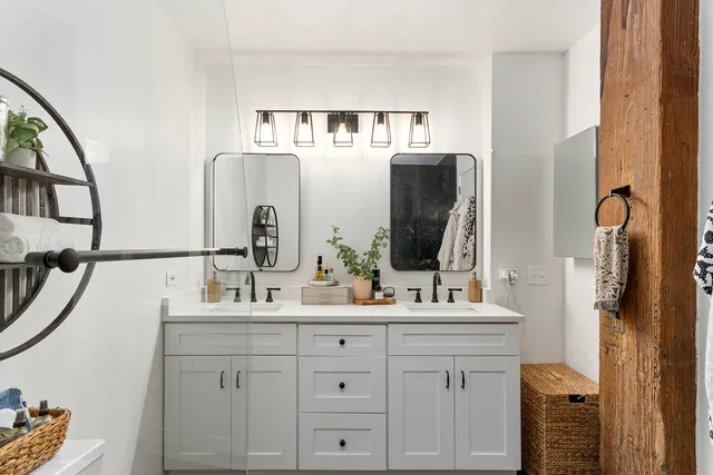 a bathroom with a double vanity sink and mirror