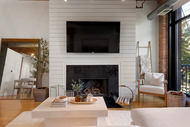 a living room with furniture a fireplace and a flat screen tv