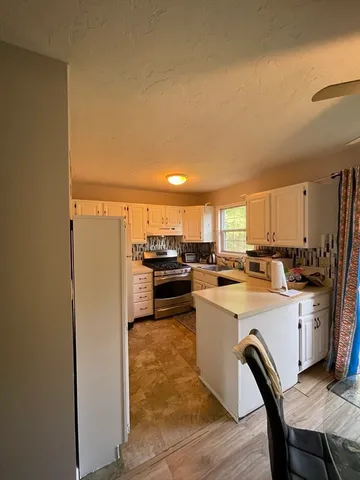 a kitchen with a sink a stove and chairs