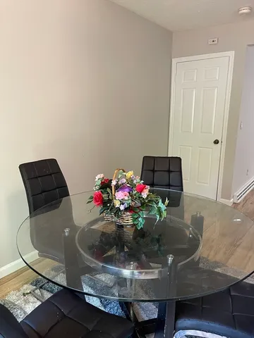 a view of a dining room with furniture and flowers