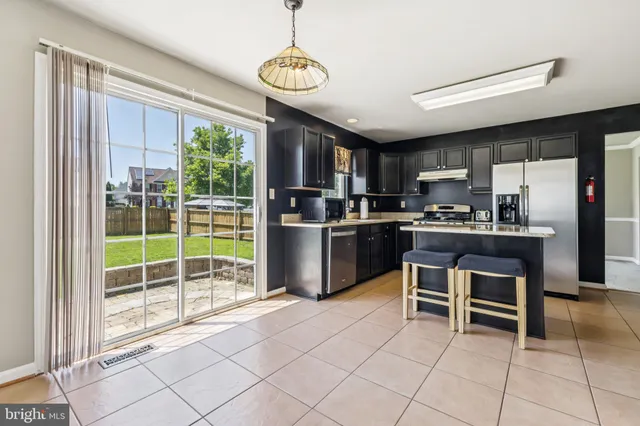 a kitchen with granite countertop a stove a sink and a refrigerator