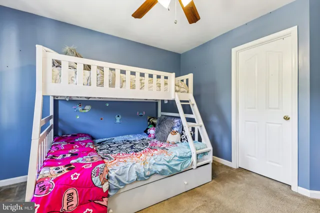 a bedroom with bed and a baby crib