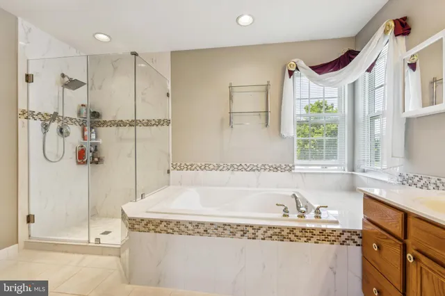 a bathroom with a granite countertop bathtub sink vanity and mirror
