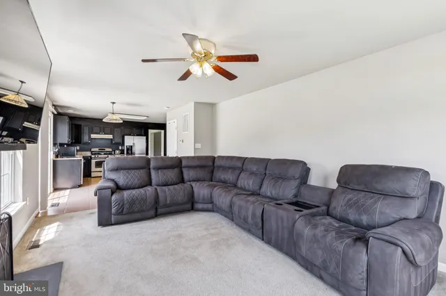 a living room with furniture and kitchen view
