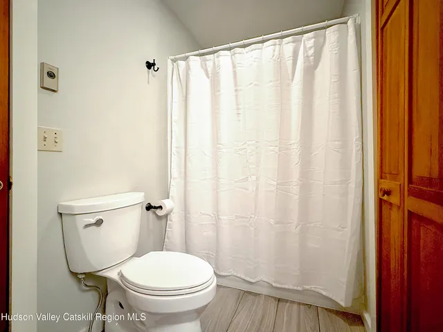 a white toilet sitting next to a shower