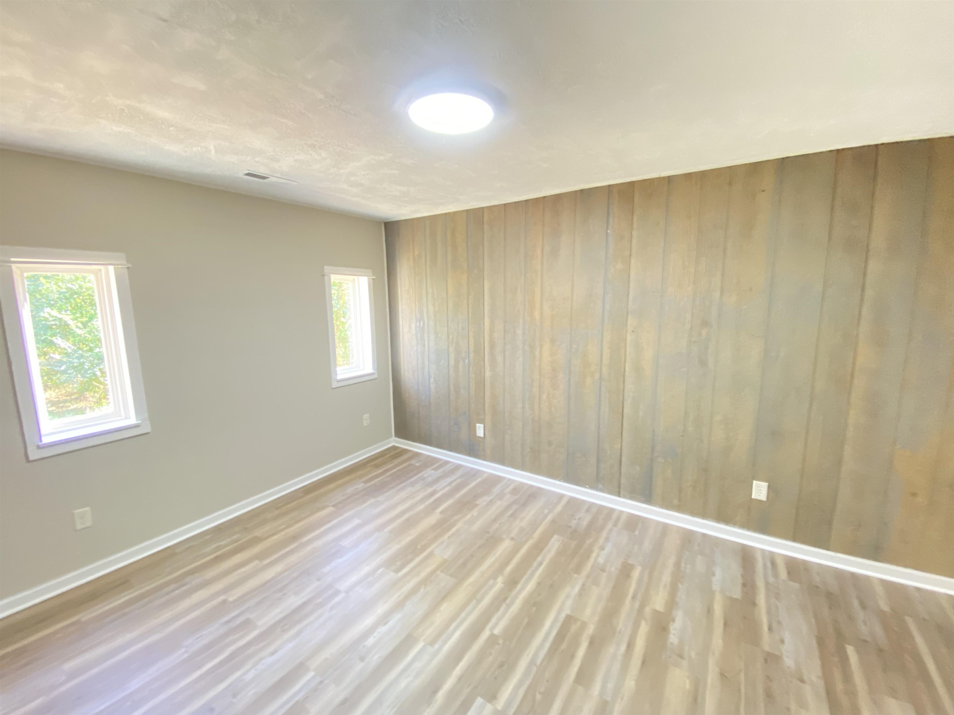 5610 Leapwood Enville Road Adamsville, TN 38310 - Photo 12 of 27 a view of an empty room with wooden floor and a window