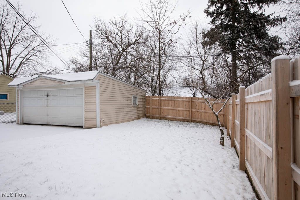 19310 Libby Road Maple Heights, OH 44137 - Photo 18 of 20 Snowy yard featuring an outdoor structure and a garage