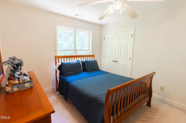 a bed sitting in a bedroom next to a window with a chandelier