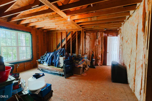 a bedroom with a bed dresser and wooden floor