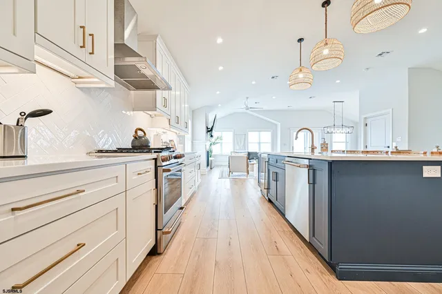 a large kitchen with stainless steel appliances kitchen island granite countertop a large counter top a sink and cabinets