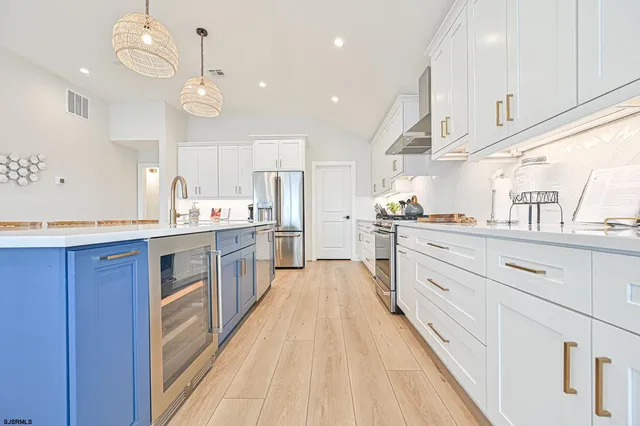 a kitchen with stainless steel appliances granite countertop a sink a stove a dining table and chairs