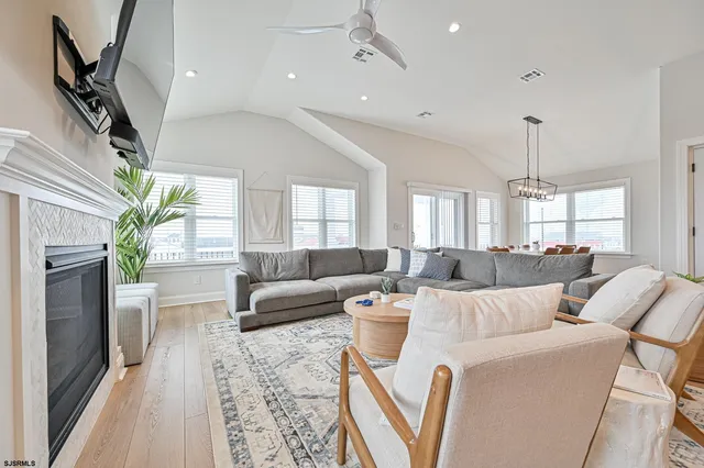 a living room with furniture a flat screen tv and a fireplace
