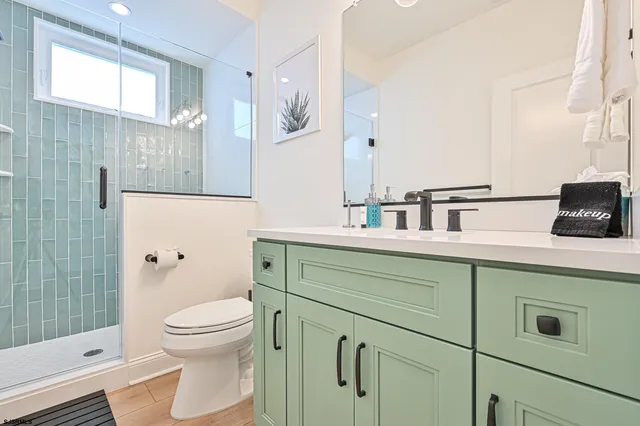 a bathroom with a granite countertop sink vanity mirror bathtub shower and a bathtub