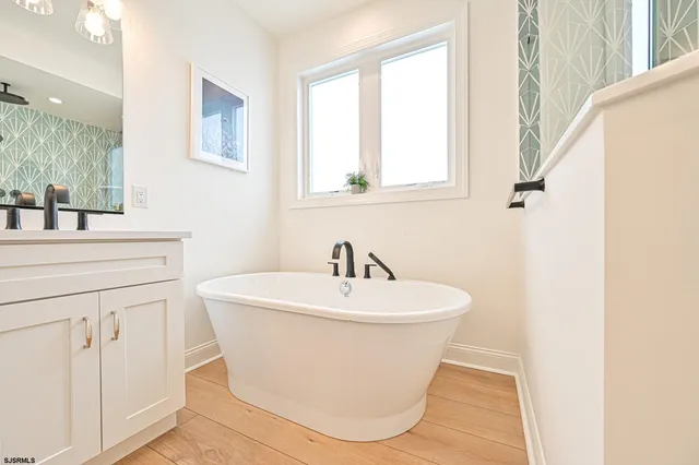 a bedroom with a bed table chair and a window