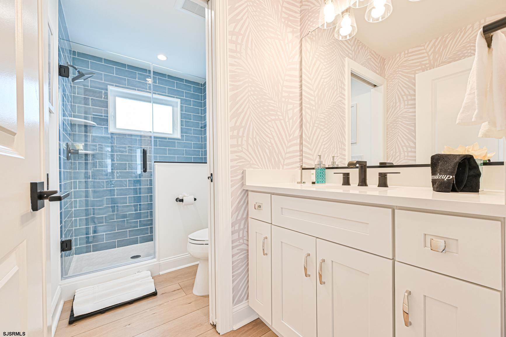 251 38th Street South Brigantine, NJ 08203 - Photo 57 of 63 a bathroom with a double vanity sink a toilet and shower