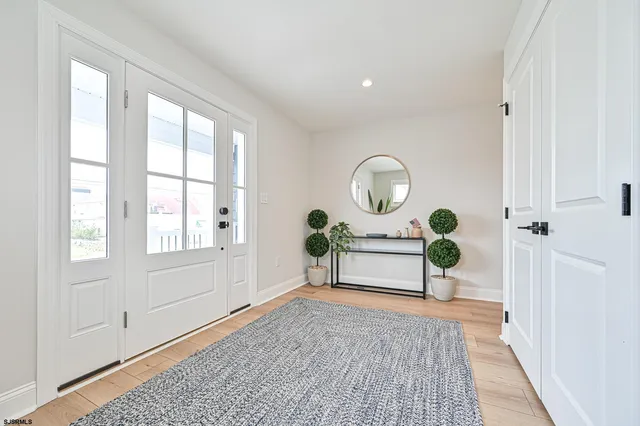 a kitchen with stainless steel appliances kitchen island granite countertop a table chairs and white cabinets