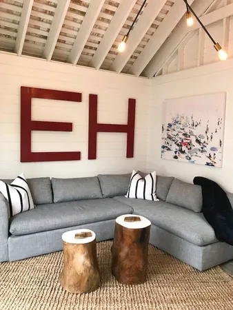 a living room with furniture a rug and a wall painting