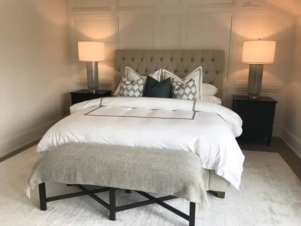 a large bed sitting in a bedroom next to a lamp