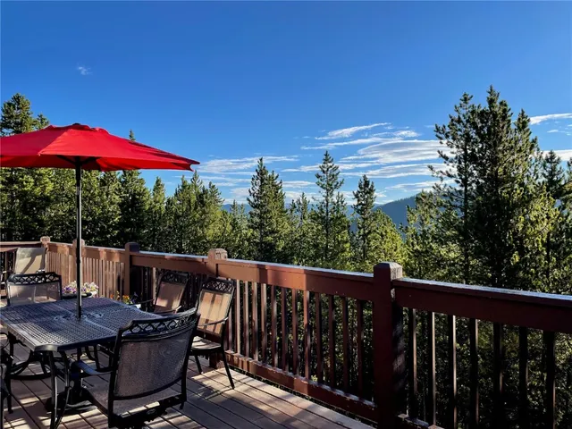 a view of a balcony with furniture and red umbrella