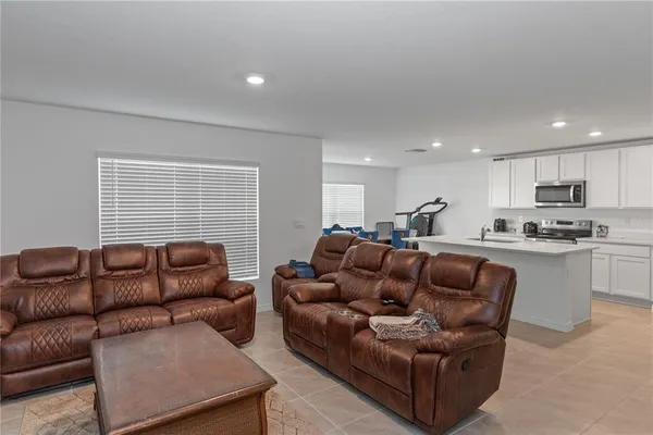 a living room with furniture white walls and kitchen view