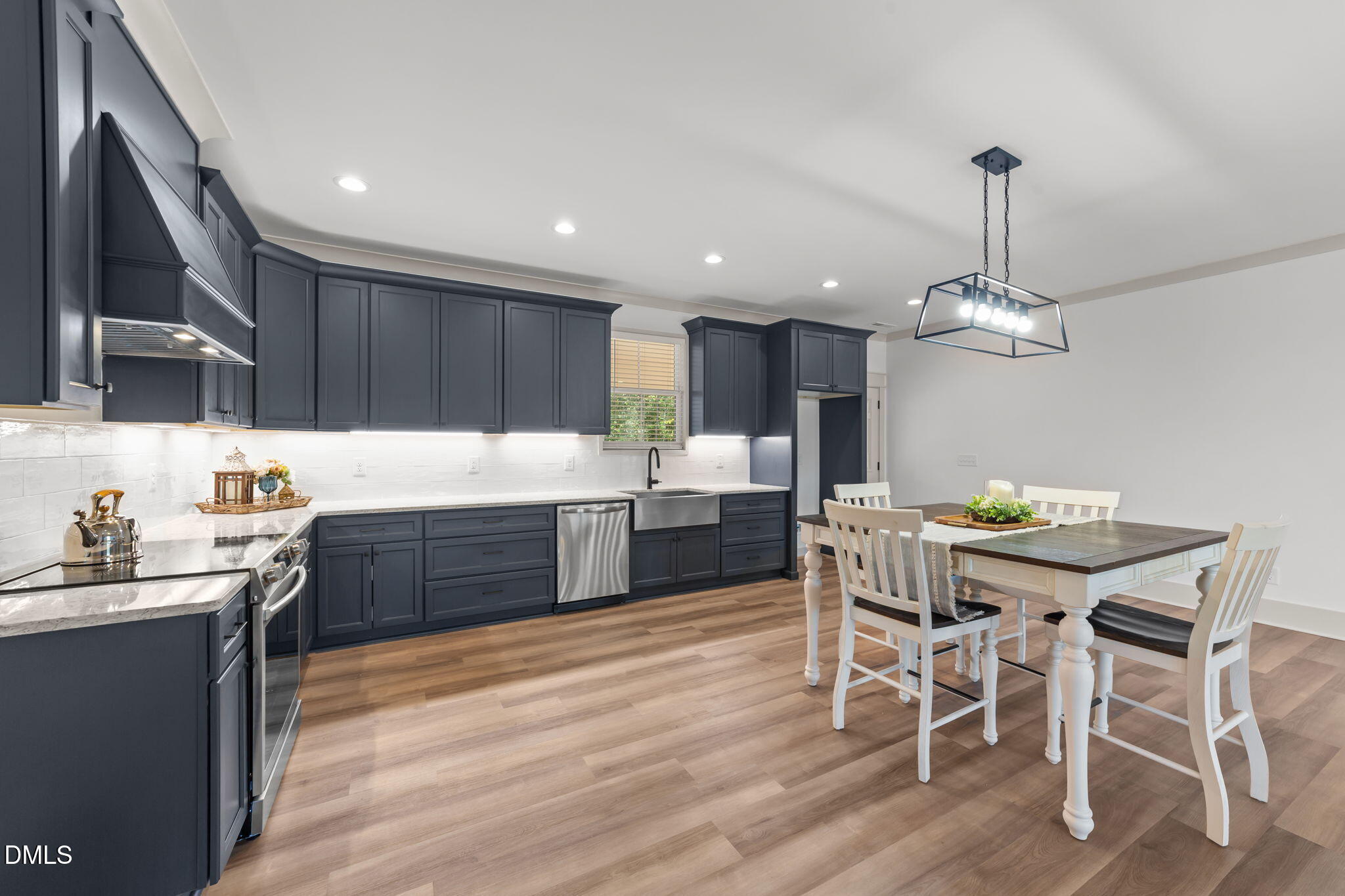 582 Harnett Central Road Fuquay-Varina, NC 27526 - Photo 27 of 51 a kitchen with granite countertop kitchen island stainless steel appliances a dining table chairs sink and cabinets