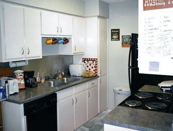 a kitchen with granite countertop a sink stove and cabinets
