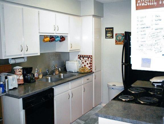 a kitchen with granite countertop a sink stove and cabinets
