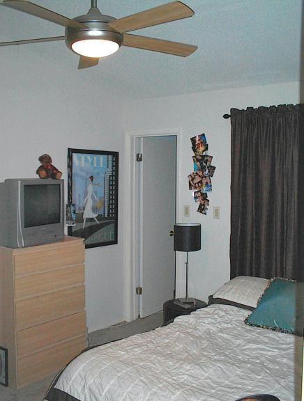 106 East 30th Street, Unit 307 Austin, TX 78705 - Photo 5 of 10 a bedroom with a bed and a chandelier