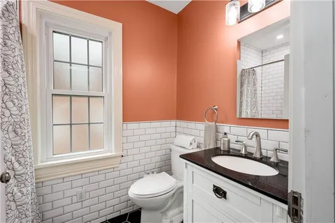 a bathroom with a granite countertop sink toilet and mirror